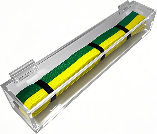 A vibrant green and yellow martial arts belt secured with black straps inside a clear acrylic display case with hinge top